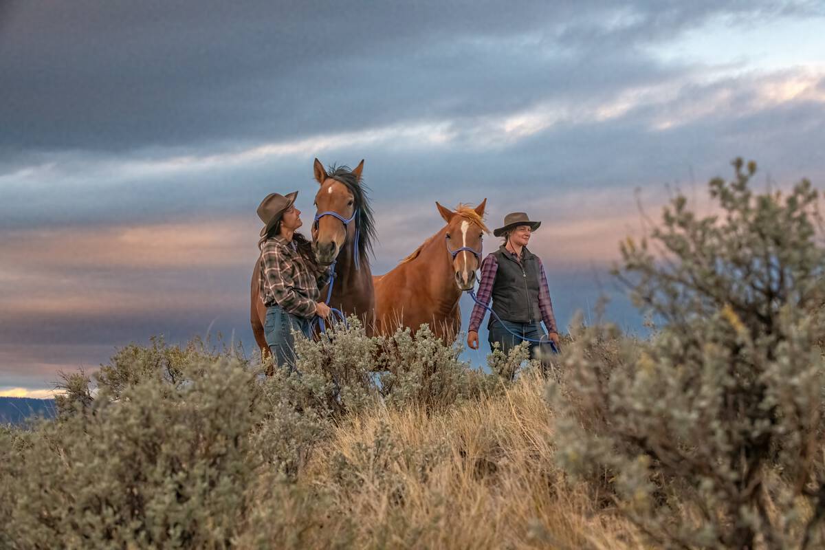 Two people walking together with horses at Sundance Guest Ranch in Ashcroft.