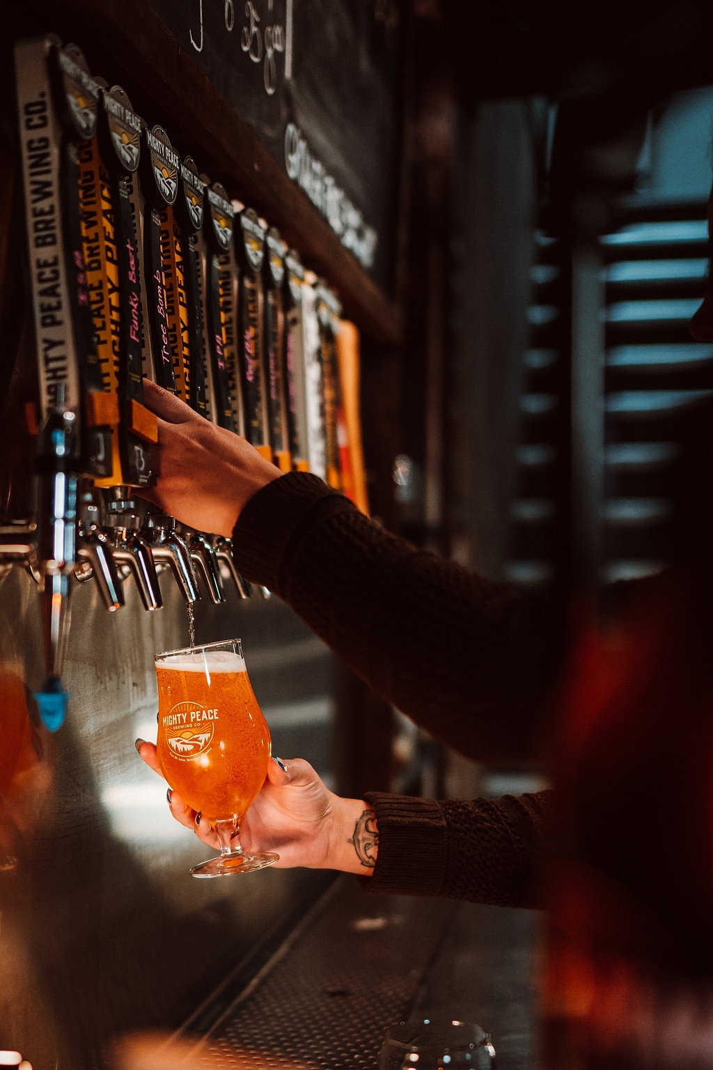 A person pours a cool pint of beer at the taps of Mighty Peace Brewery in Fort St. John.