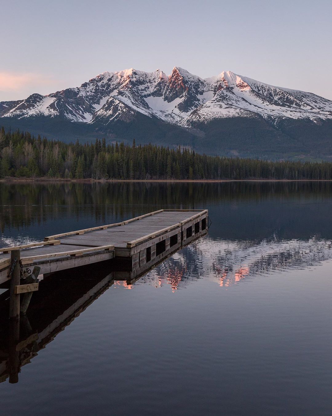 photo by Jason Mcintosh caption reads: Gravel roads always lead to the best places. Northern BC lake vibes, with Hudson Bay Mountain in the distance.  I can still hear the Loons! 
.
.
.
.
.
.
.
.
.
.
.
.
.
#hudsonbaymountain #smithers  #smithersbc #smithersvibe #dennislakebc #explorebc #explorecanada #northernbc #bulkleyvalley #terracebc #bcisbeautiful #reflection #lakevibes #summervibes #dailyviewbc #britishcolumbia #pnw #cascadiaexplored #canadiancreatives #exploremore #canadasworld #canada #mountainlife #camping #tourcanada #outdoortones #pnwwilderness @hellobc #52weeksofnature #roamtheplanet